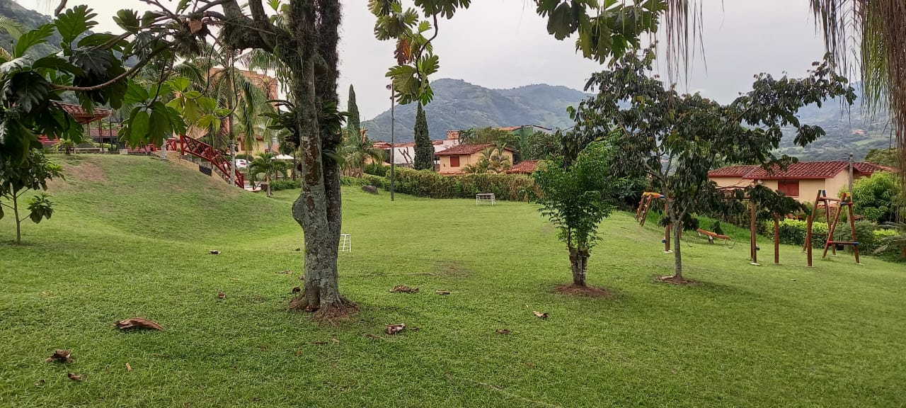 Amplia zona verde común rodeada de montañas en la parcelación